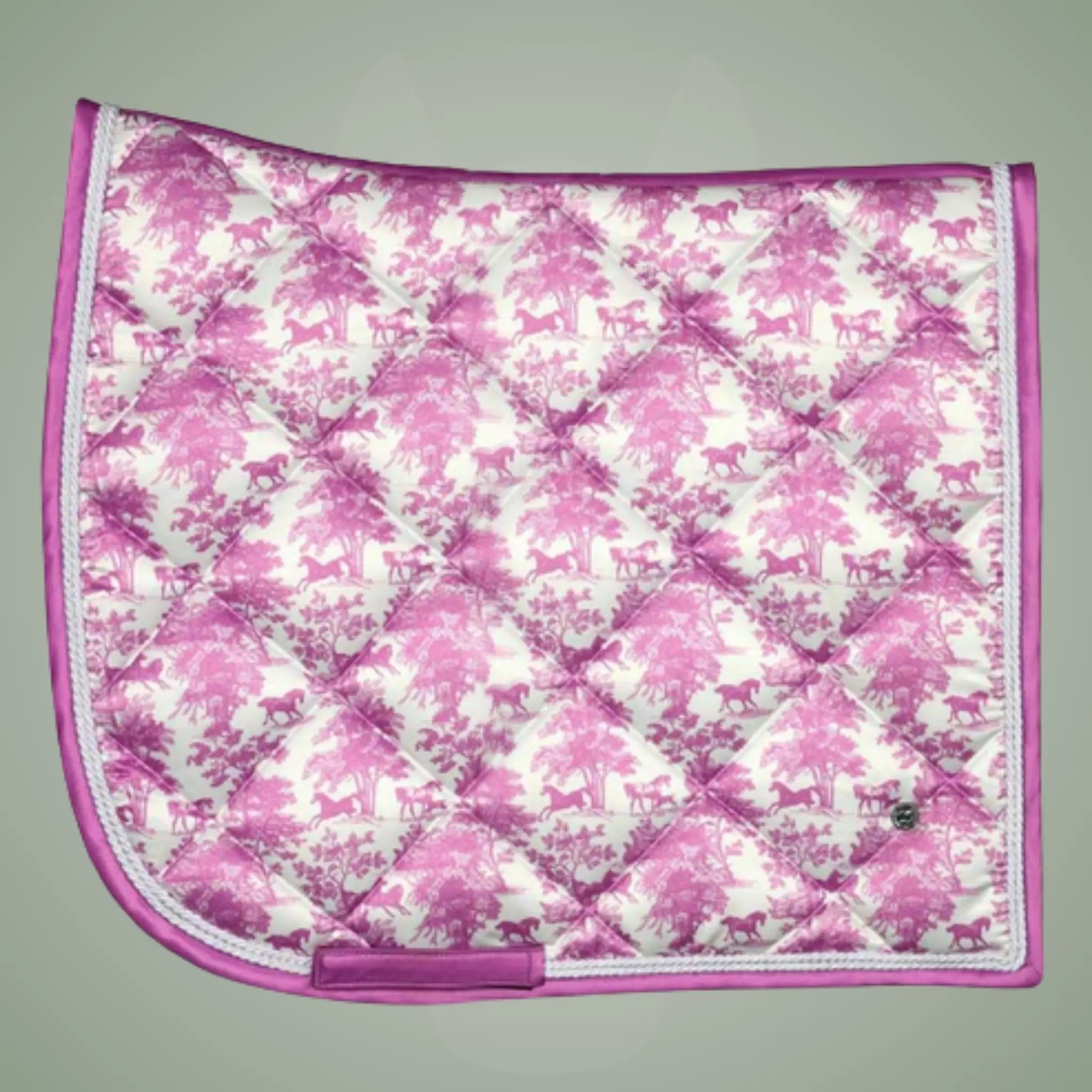 Pink and white quilted saddle pad with horse pattern on a gray background