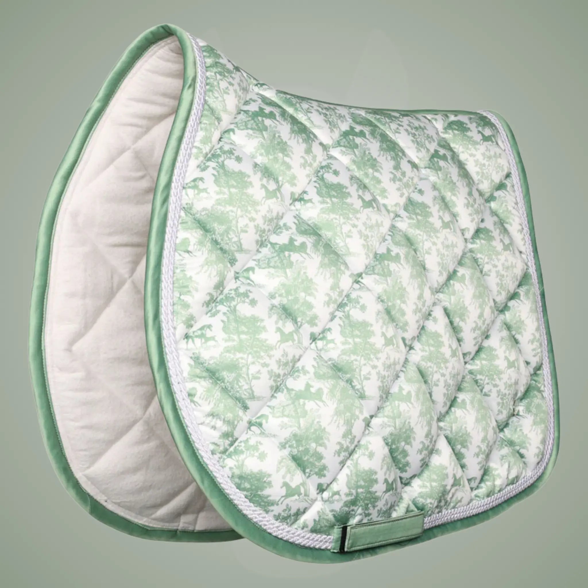 Green and white quilted saddle pad on a gray background