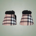 Pair of plaid horse boots with black fur trim on a light gray background
