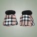 Pair of plaid horse boots with black fur lining on a light gray background