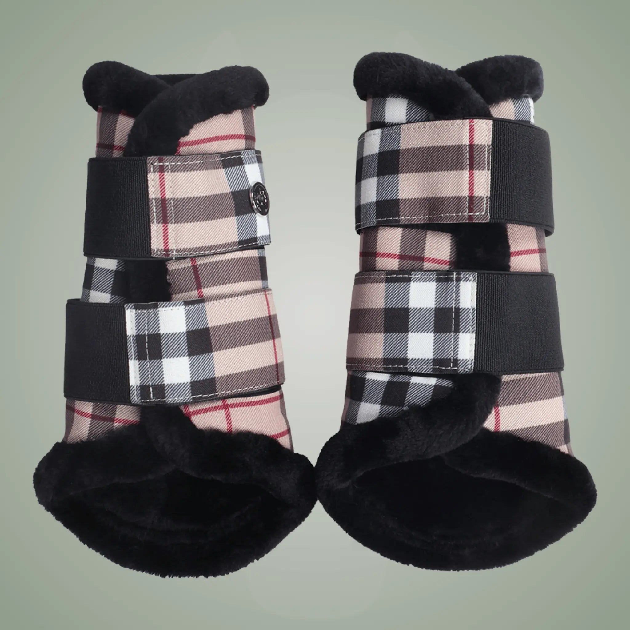 Pair of plaid protective booties with black straps on a light green background