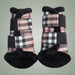 Pair of plaid protective booties with black straps on a light green background