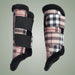 Pair of plaid leg wraps with black straps on a light gray background