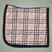 Plaid patterned saddle pad with black border on a light green background