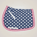 Navy blue saddle pad with white polka dots and pink border on a beige background