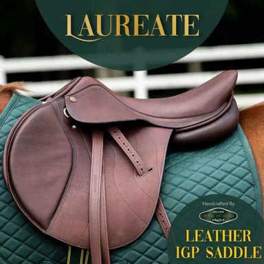 Brown leather saddle on a green quilted pad with 'Laureate' branding.