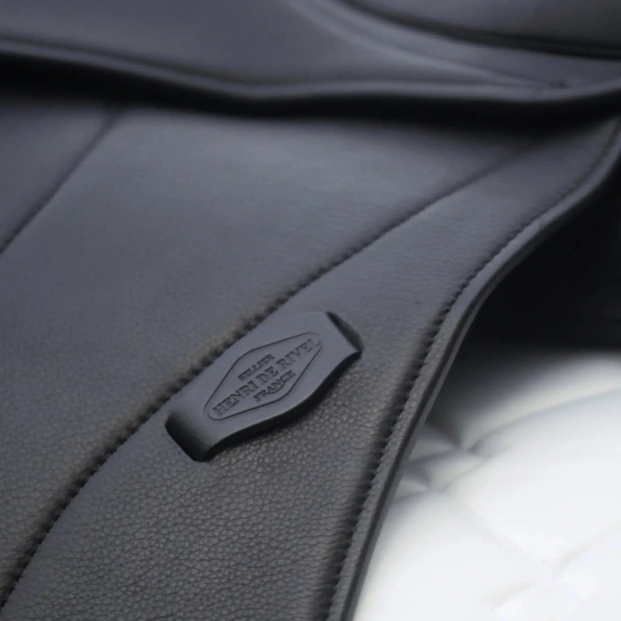 Close-up of a black leather saddle with a visible HDR brand logo.
