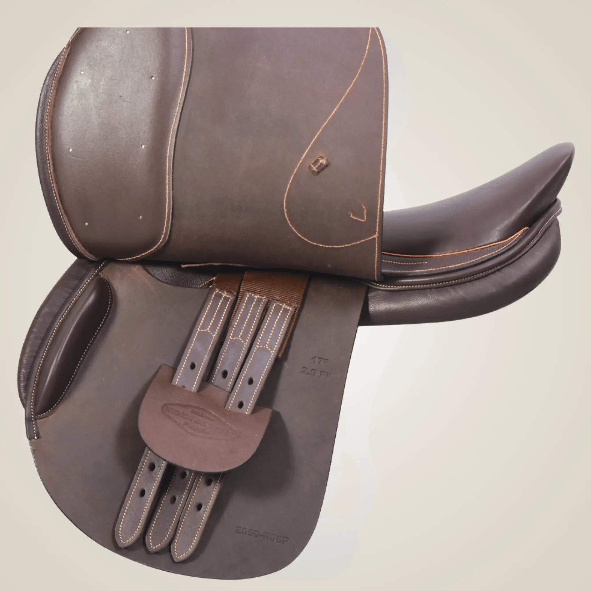 Brown leather saddle with decorative stitching on a beige background