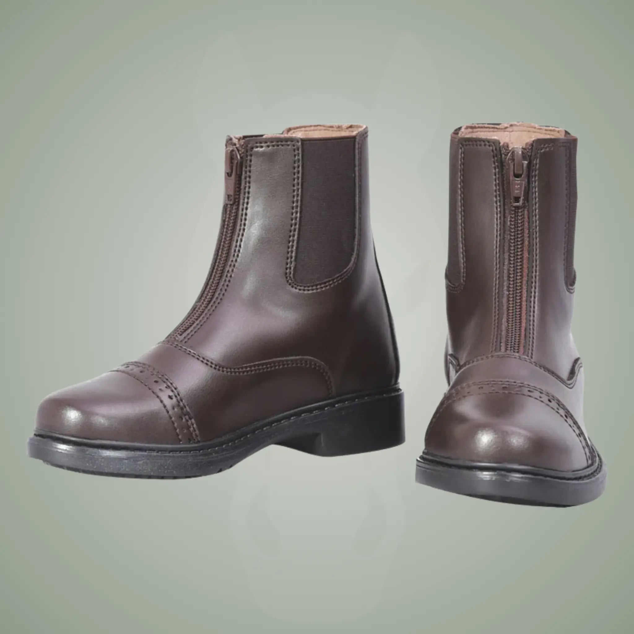 Pair of brown leather boots with zippers on a light green background