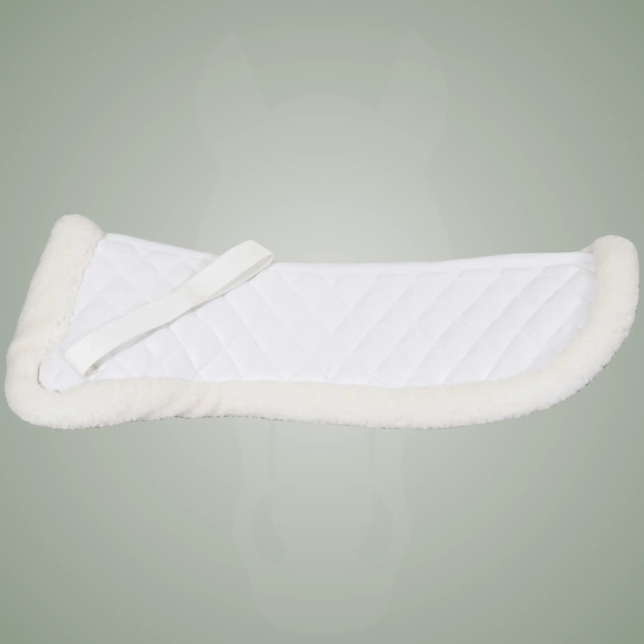 White sheepskin saddle pad on a gray/green background