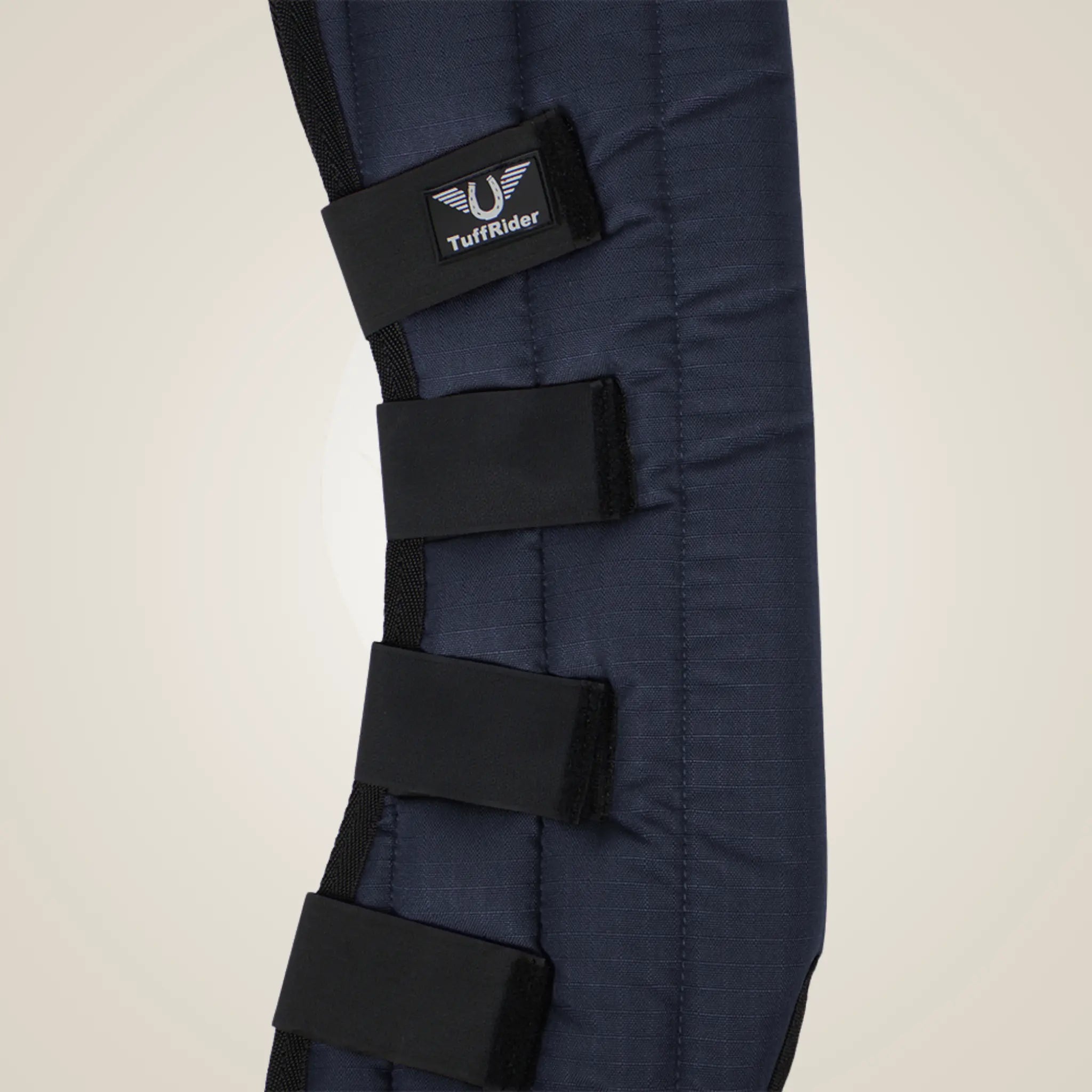 Navy blue protective leg wrap with black straps on a beige background